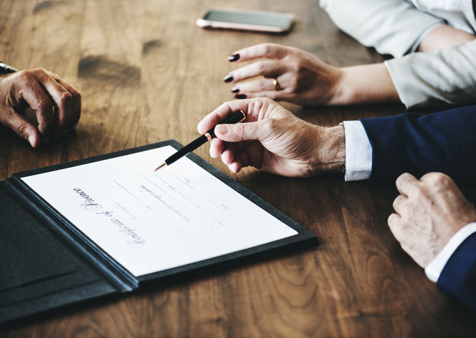 mennesker underskriver en kontrakt