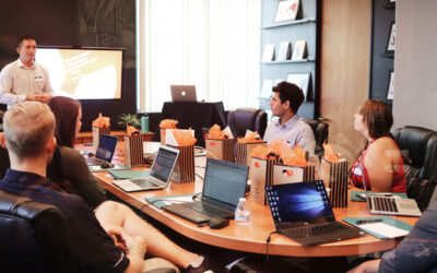 Person holder oplæg for en gruppe mennesker. De sidder med hver sin computer.