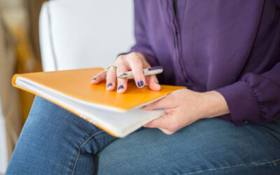 person sidder klar til at skrive noget ned